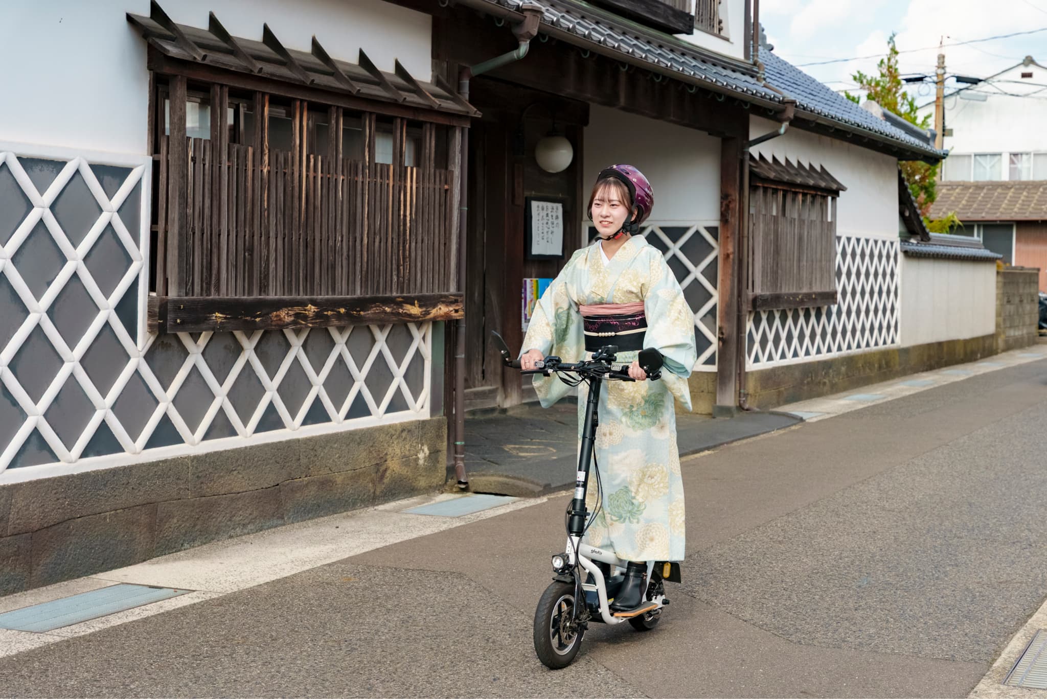 着物を着て電動キックボードで走るスマイルサポーター